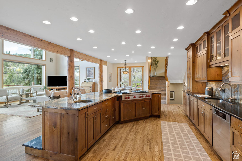 Kitchen featuring a center island with sink, light hardwood / wood-style floors, sink, and appliances with stainless steel finishes