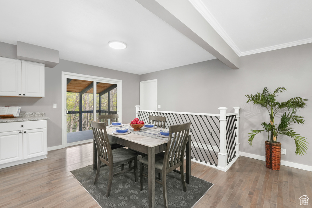 Dining space with beam ceiling and hardwood / wood-style flooring