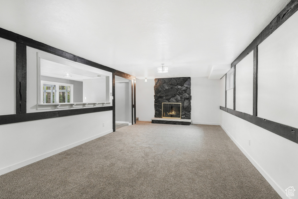 Unfurnished living room with a fireplace and carpet floors