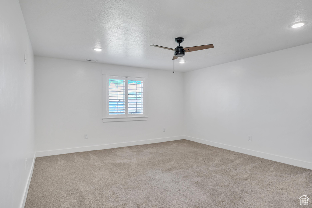 Empty room with carpet and ceiling fan