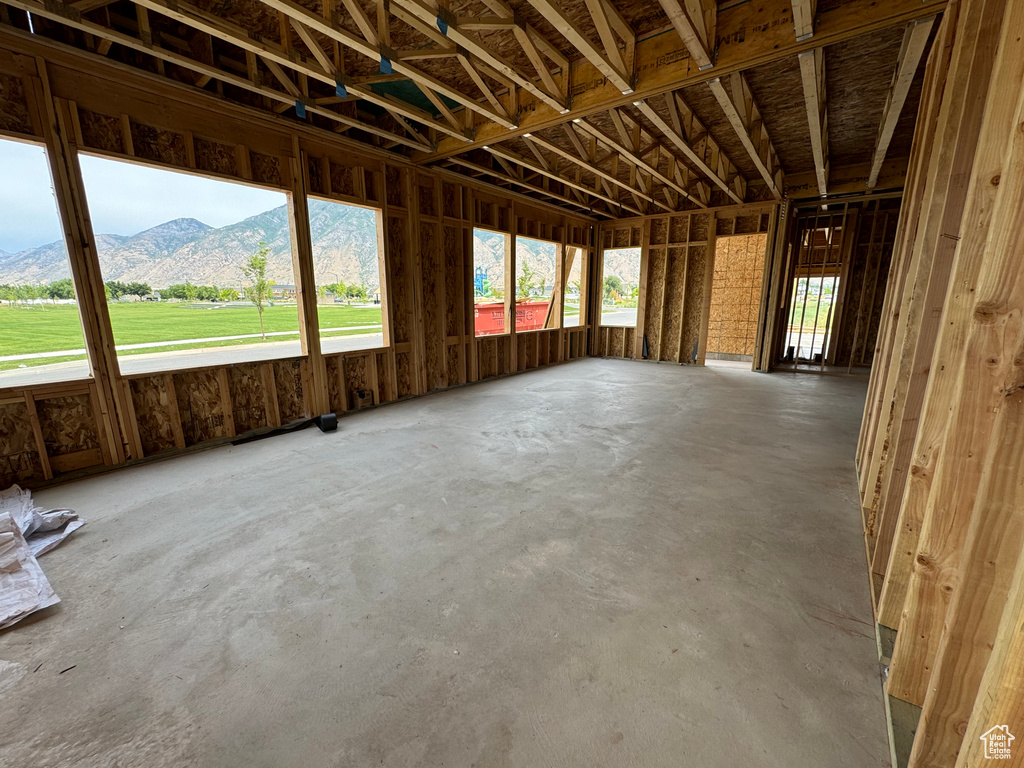 Misc room featuring a mountain view, a healthy amount of sunlight, and concrete flooring