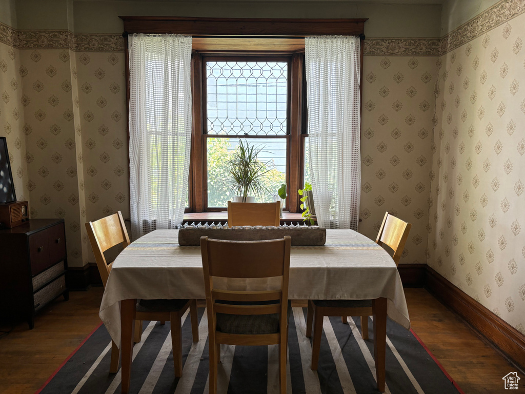 Dining area with dark hardwood / wood-style flooring and plenty of natural light