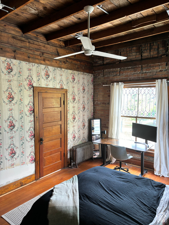 Bedroom with ceiling fan, radiator heating unit, beamed ceiling, wood ceiling, and hardwood / wood-style flooring