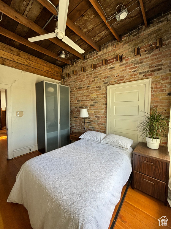 Bedroom featuring beamed ceiling, ceiling fan, light hardwood / wood-style flooring, and wooden ceiling