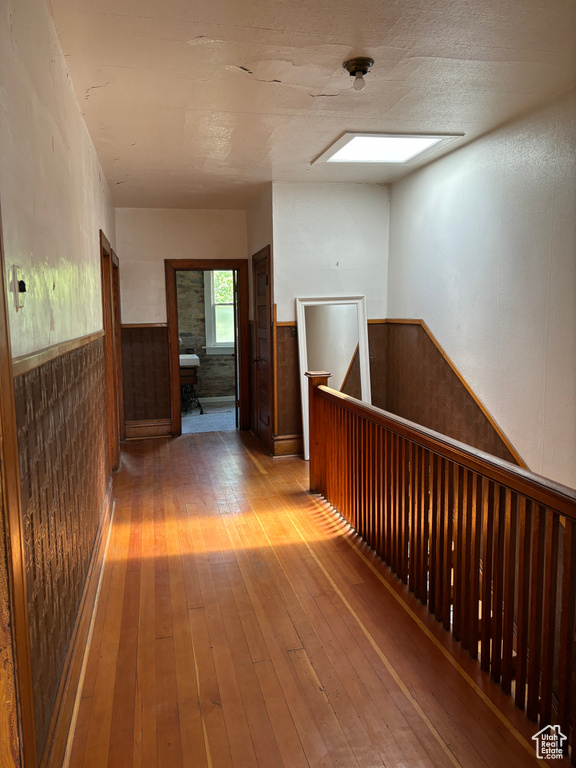 Hallway featuring hardwood / wood-style flooring and a skylight