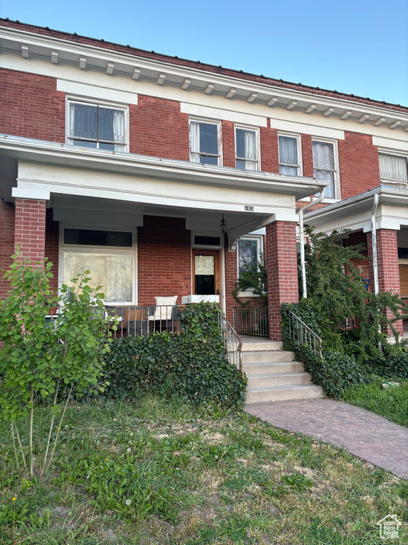 Townhome / multi-family property with a porch