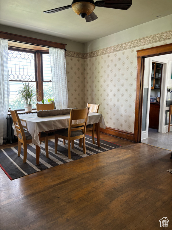 Dining area with dark hardwood / wood-style flooring and ceiling fan