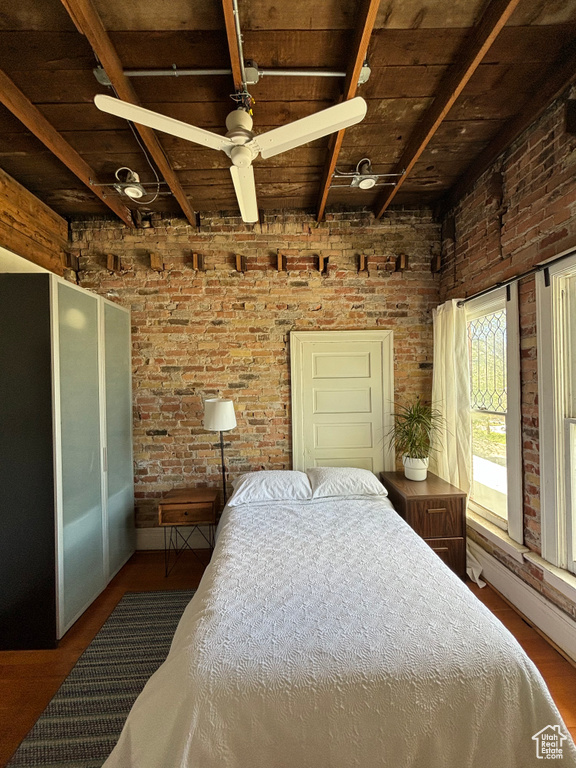 Bedroom featuring hardwood / wood-style floors, brick wall, and wooden ceiling