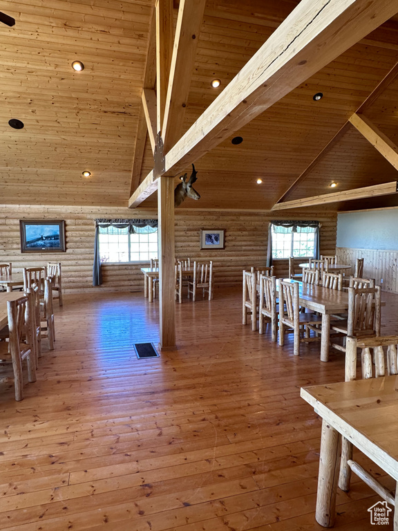 Unfurnished dining area with high vaulted ceiling, wood-type flooring, beamed ceiling, and wood ceiling