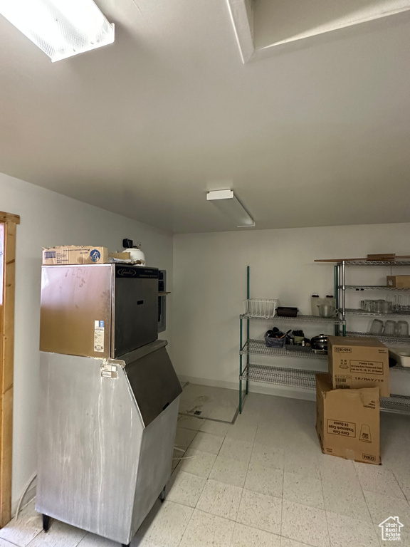 Kitchen featuring fridge and tile floors