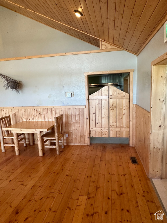 Unfurnished dining area with hardwood / wood-style flooring, lofted ceiling, and wood ceiling