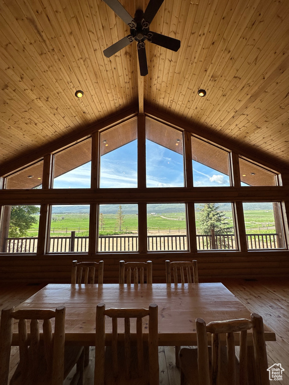 Dining space with high vaulted ceiling, a wealth of natural light, wood ceiling, and hardwood / wood-style floors