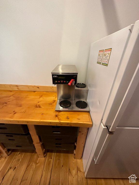 Interior details with light hardwood / wood-style floors and white refrigerator