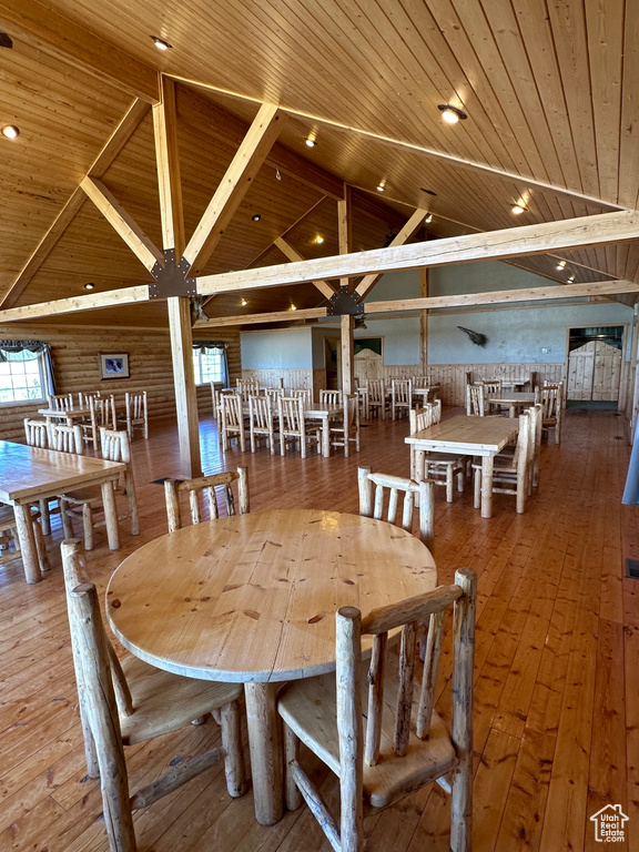 Dining area with high vaulted ceiling, hardwood / wood-style flooring, and wood ceiling