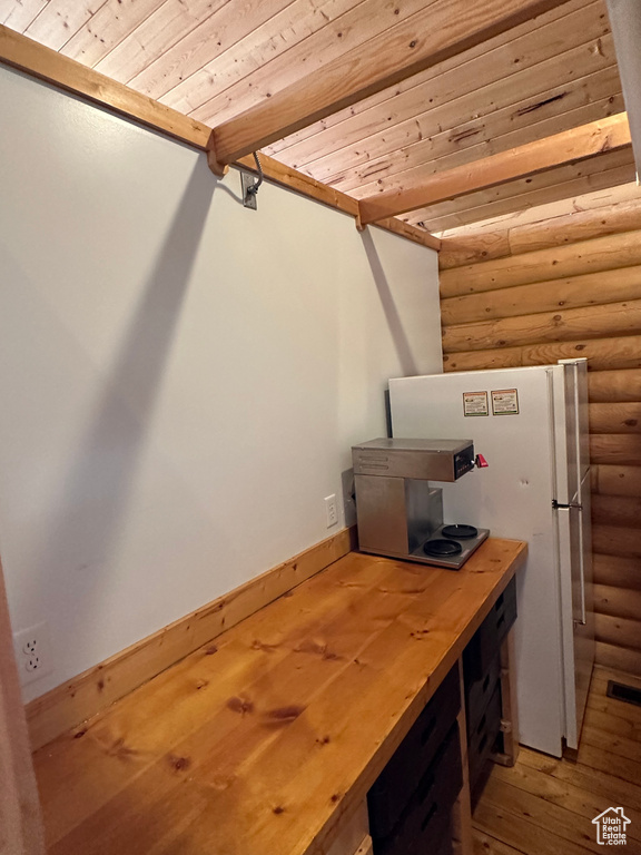 Office space featuring hardwood / wood-style floors, rustic walls, and wood ceiling