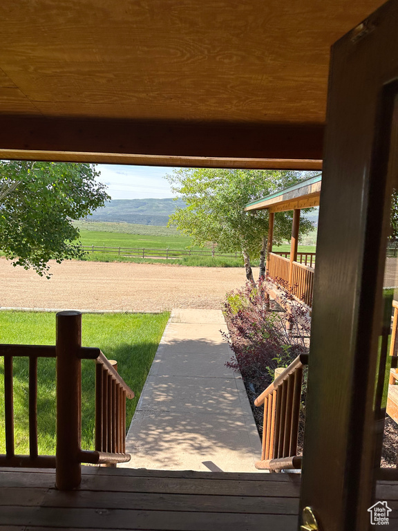 Wooden terrace featuring a mountain view and a lawn