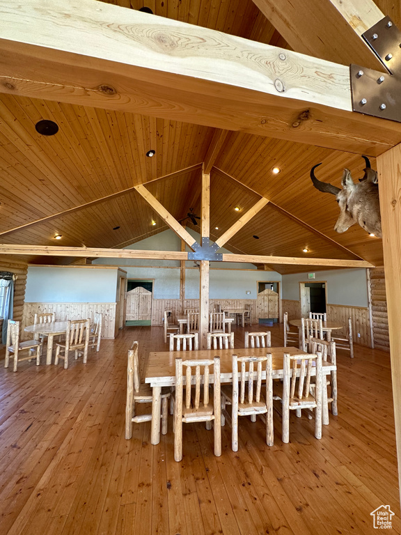 Unfurnished dining area with beam ceiling, hardwood / wood-style flooring, and wood ceiling