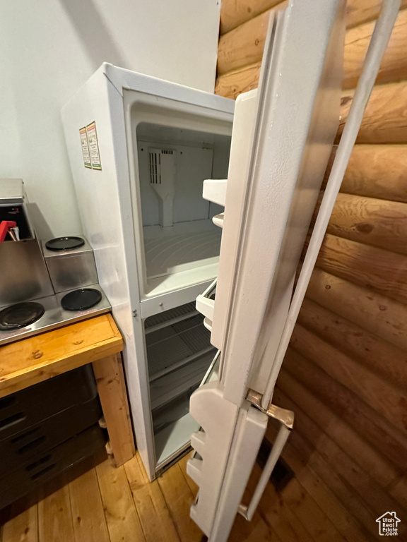 Details featuring light hardwood / wood-style floors and log walls