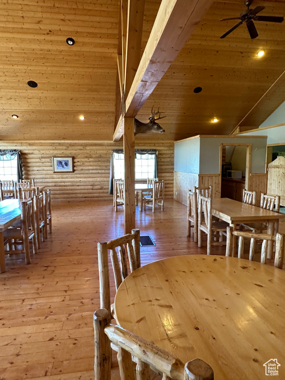 Dining room featuring ceiling fan, rustic walls, light hardwood / wood-style flooring, and wood ceiling