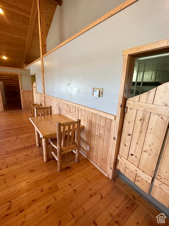 Dining room with high vaulted ceiling and hardwood / wood-style floors