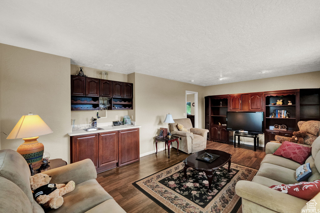 Living room with a textured ceiling and dark hardwood / wood-style floors