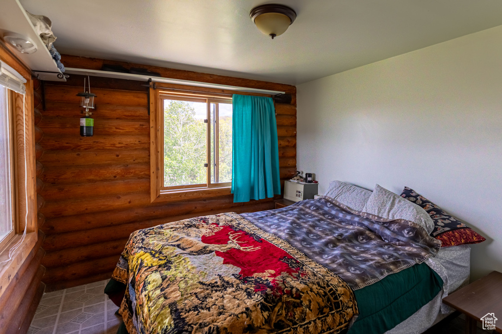 Bedroom featuring log walls