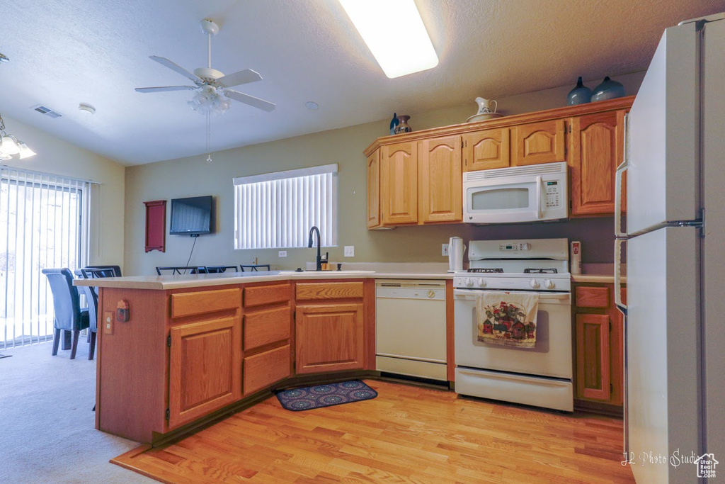 Kitchen featuring ceiling fan, light wood-type flooring, sink, white appliances, and lofted ceiling