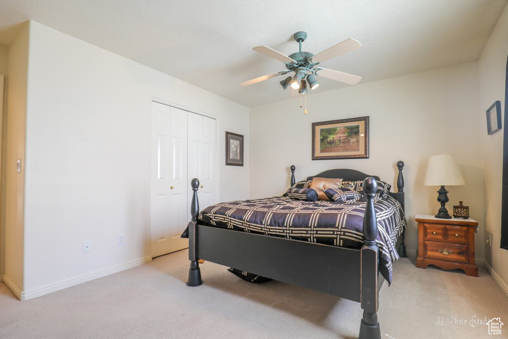 Bedroom featuring ceiling fan, a closet, and carpet flooring