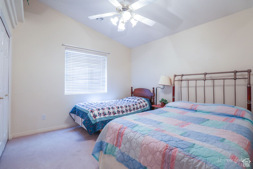 Bedroom featuring carpet flooring, a closet, ceiling fan, and vaulted ceiling