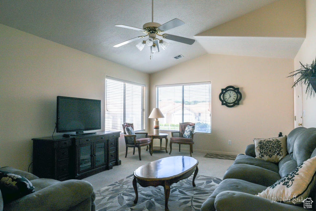 Living room featuring ceiling fan, carpet floors, and vaulted ceiling