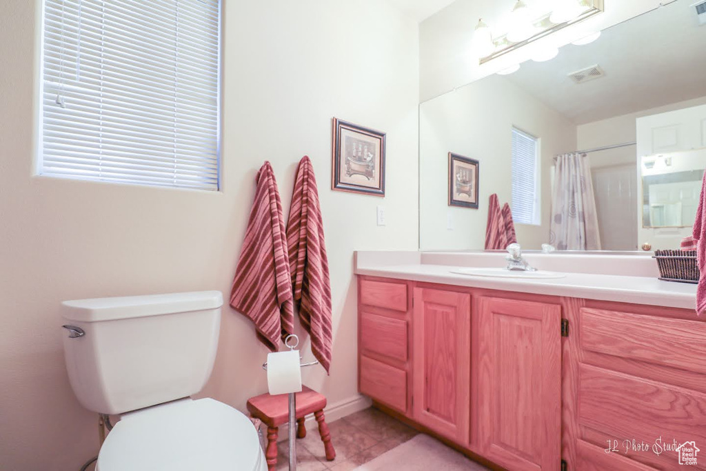 Bathroom with tile flooring, vanity, and toilet