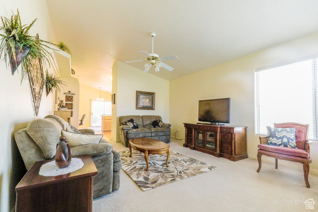 Carpeted living room with lofted ceiling and ceiling fan