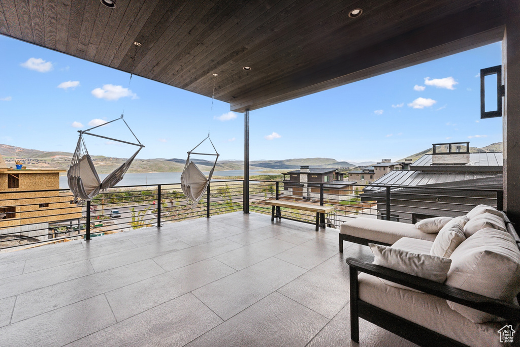 View of patio / terrace with an outdoor hangout area, a balcony, and a water view