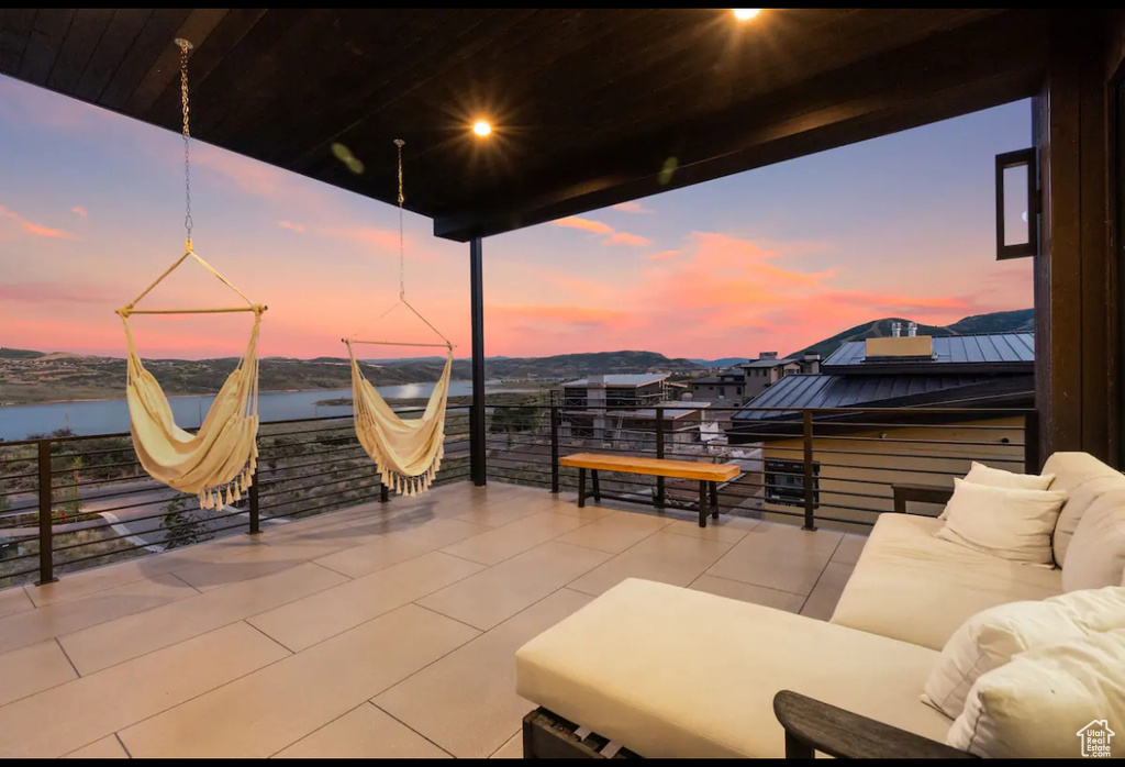 Patio terrace at dusk with a water view and a balcony