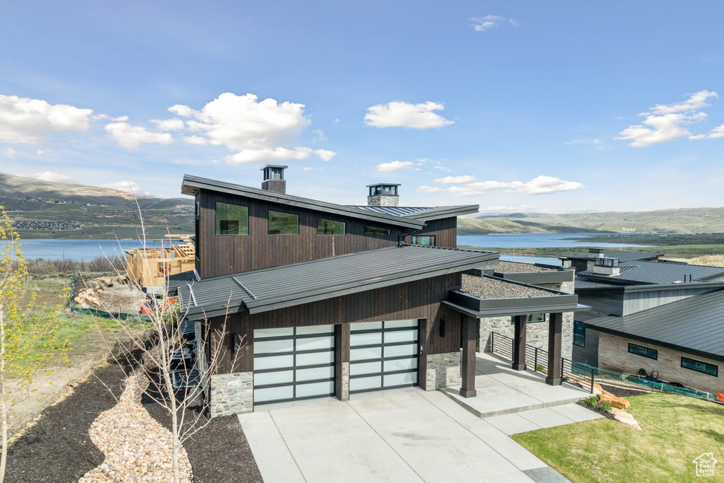 Modern home featuring a garage and a water view