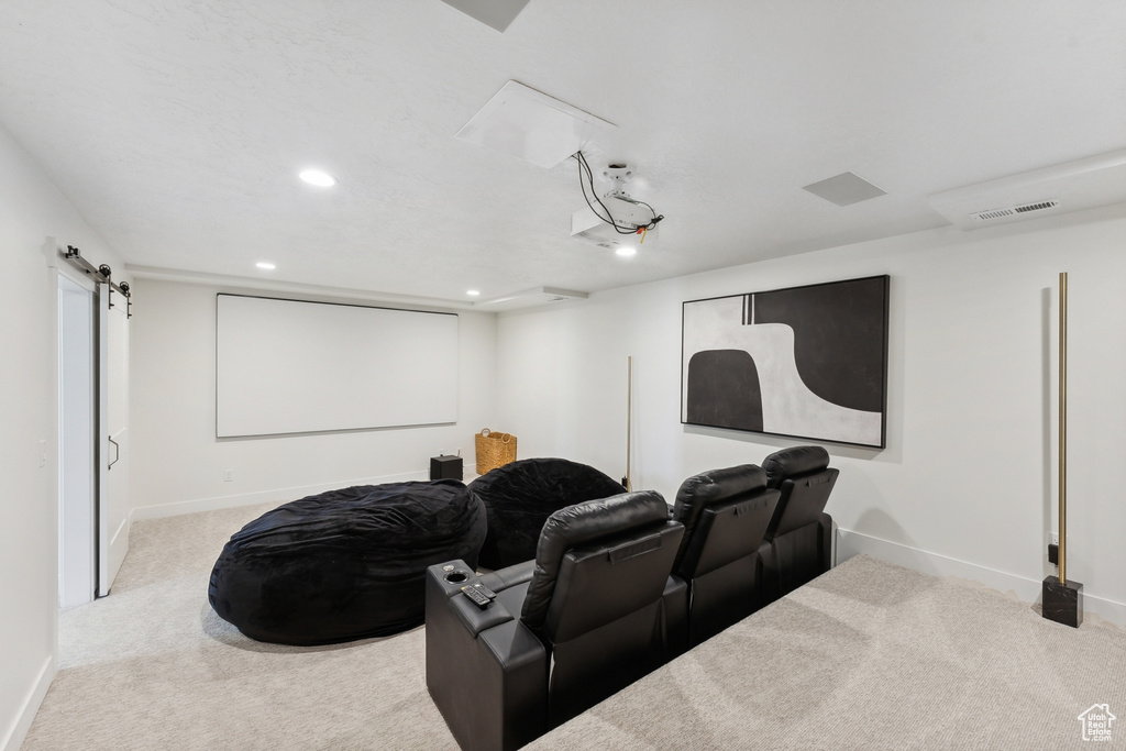 Home theater featuring a barn door and carpet floors