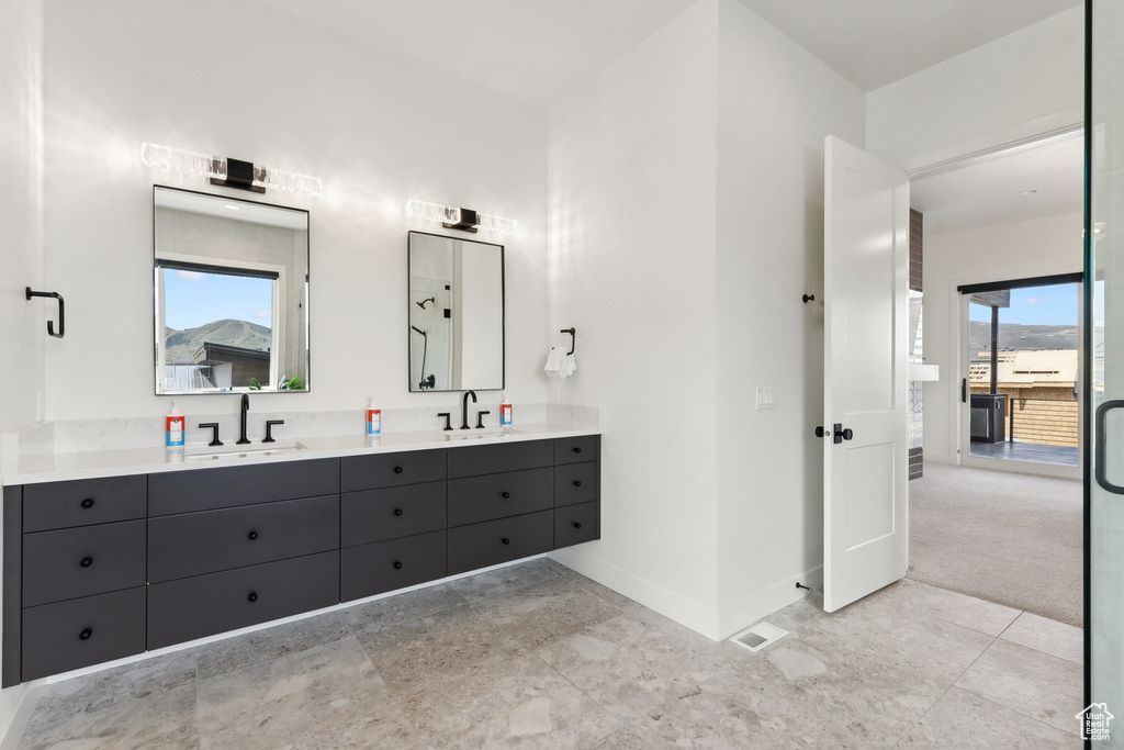 Bathroom with a wealth of natural light, tile flooring, double sink, and oversized vanity