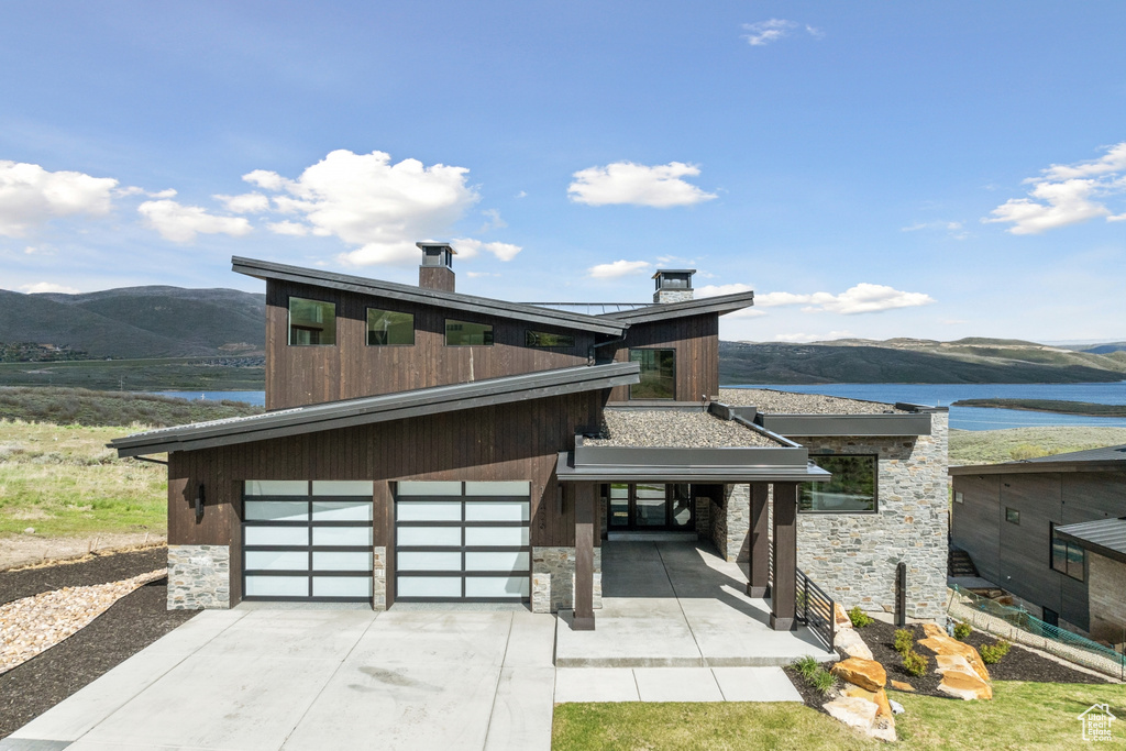 Contemporary house with a water and mountain view and a garage