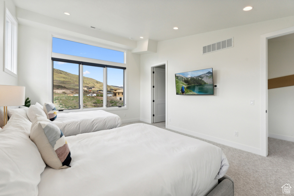 Bedroom featuring multiple windows and light colored carpet