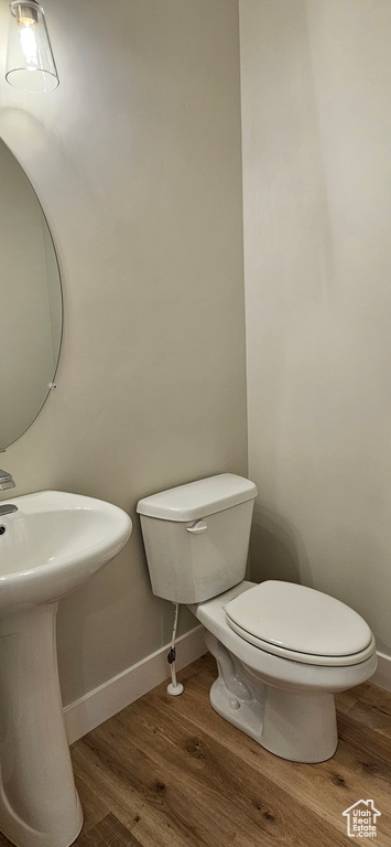 Bathroom with hardwood / wood-style flooring and toilet