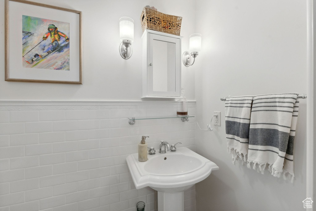 Bathroom featuring tile walls and sink