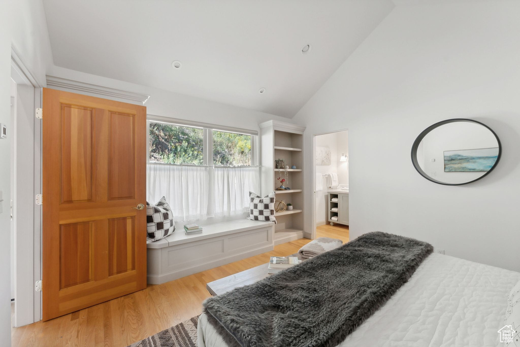 Bedroom with high vaulted ceiling and light hardwood / wood-style flooring