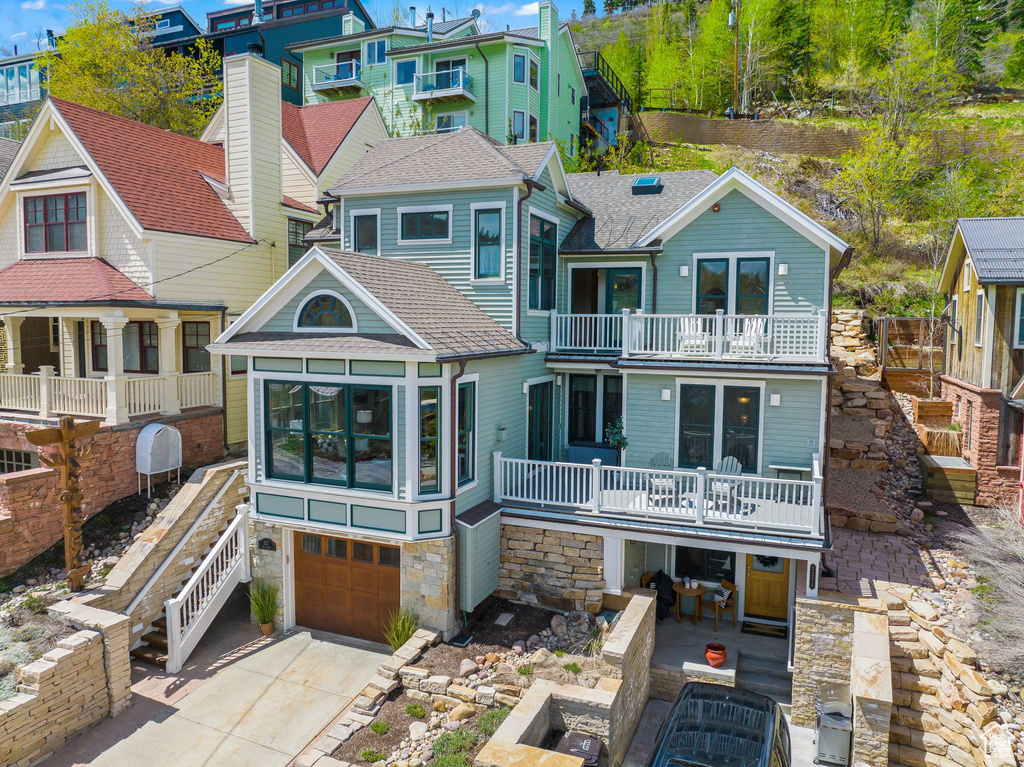 Back of property with a balcony, a garage, and a patio