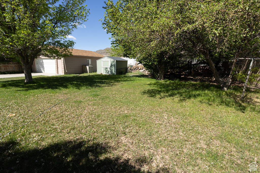 View of yard with a garage and a storage unit