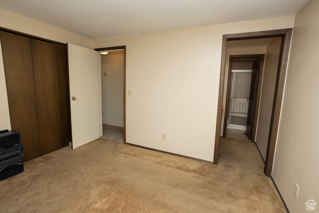 Unfurnished bedroom with a closet and light colored carpet