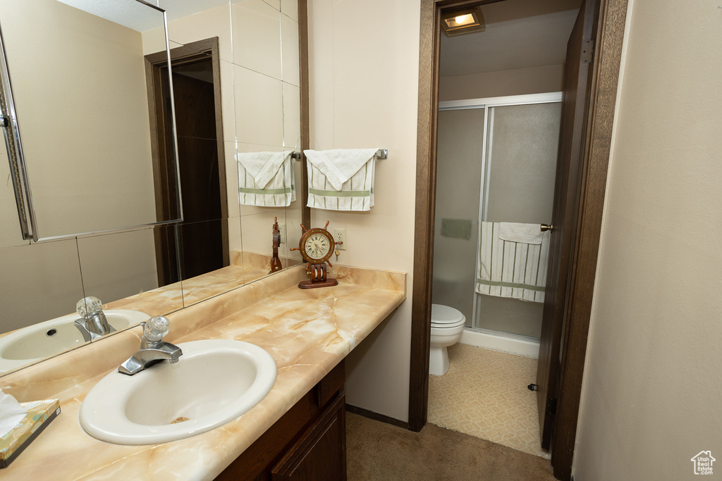 Bathroom featuring toilet, tile floors, and large vanity