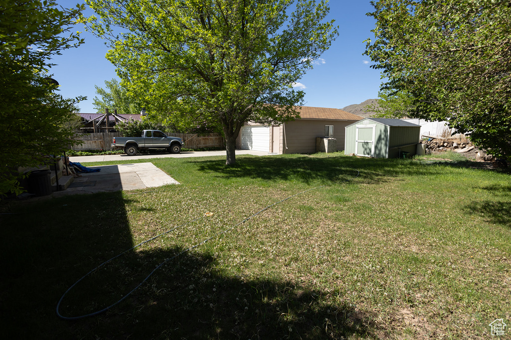 View of yard featuring a garage and a storage shed