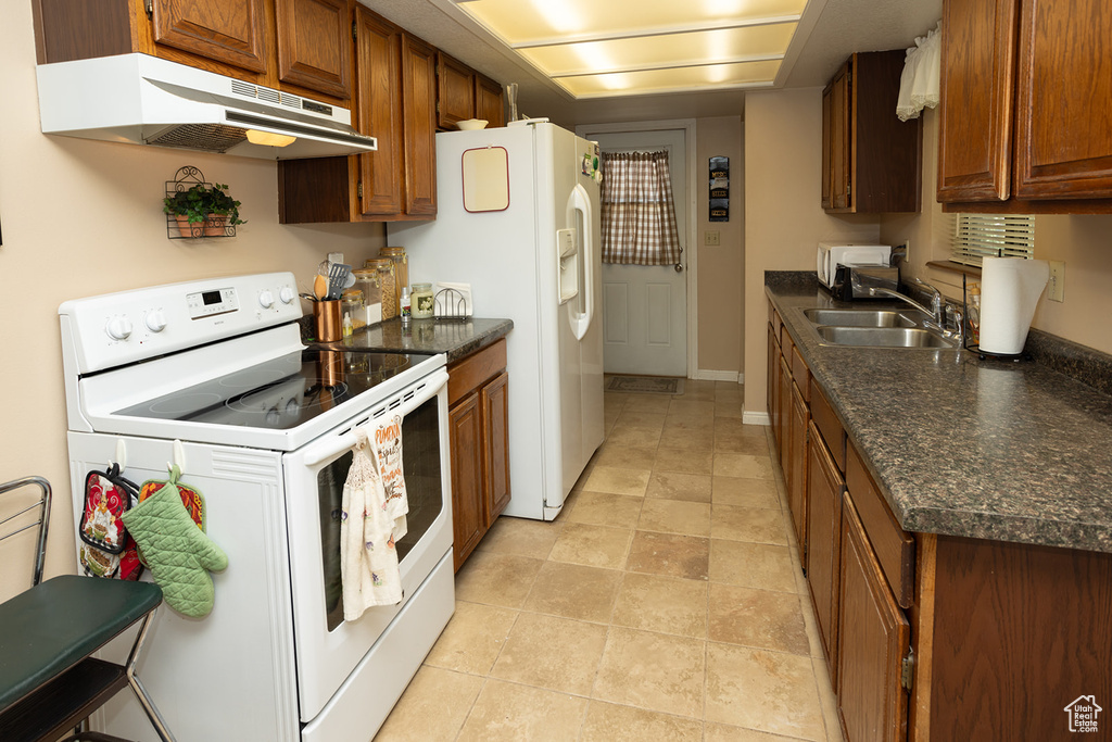 Kitchen with sink, electric range, and light tile floors