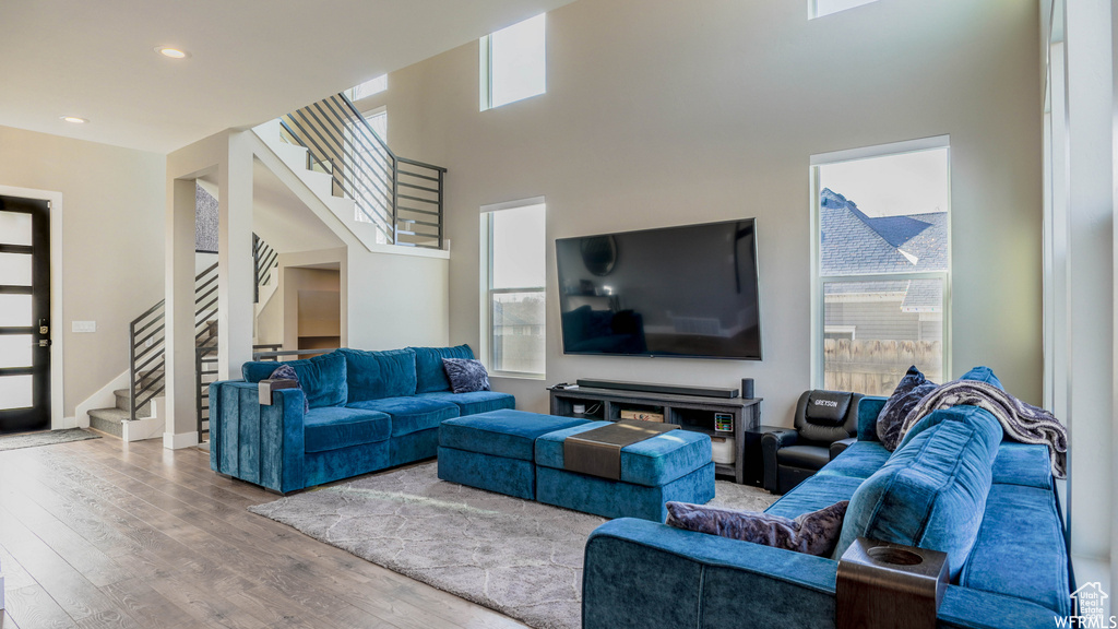 Living room featuring a towering ceiling and wood-type flooring