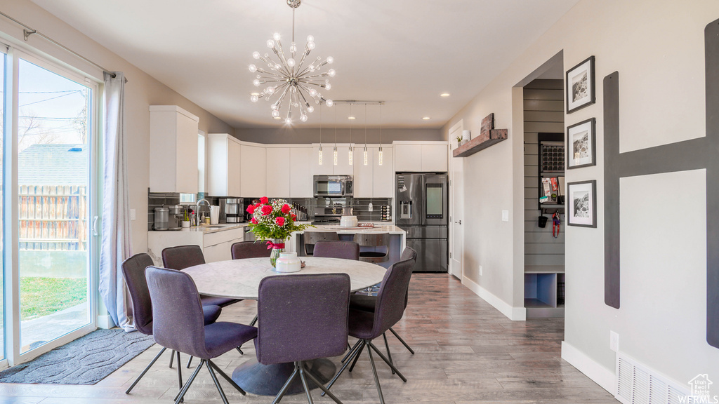 Dining area featuring light hardwood / wood-style floors, sink, and a notable chandelier